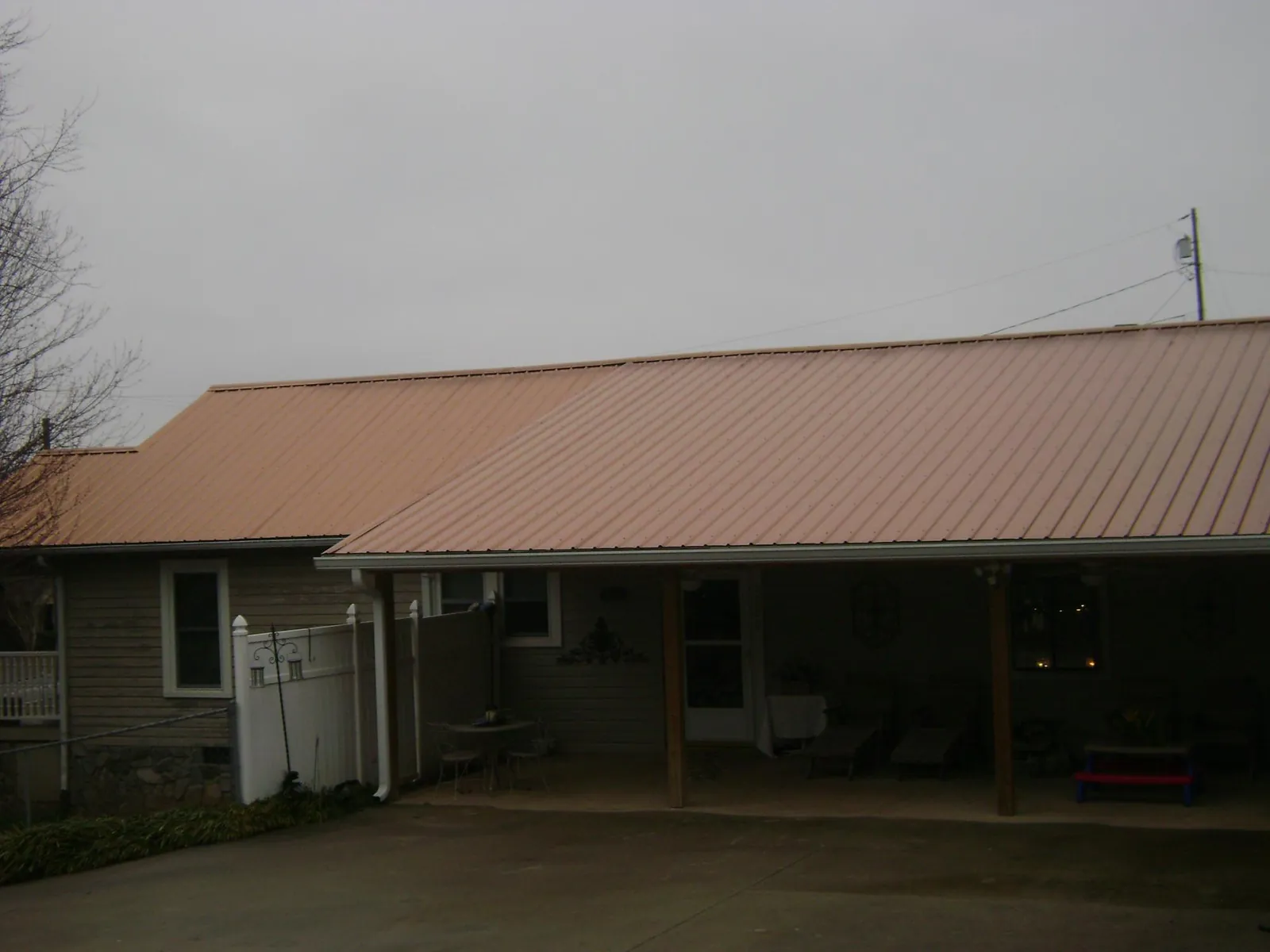 Copper toned metal roof over a wide covered patio in Linden